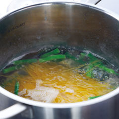 塩を入れて沸騰させたお湯にじゃがいもを入れ、再び沸騰したらさやいんげんを加える。再び沸騰したらスパゲッティを加えて袋の表示時間より１分３０秒短く茹でる。茹で汁はとっておく。