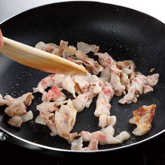豚肉は約２ｃｍ幅に切り、塩を３つまみ振ってなじませる。フッ素樹脂加工のフライパンに油をひかずに薄く広げて中火にかけ、混ぜないでおく。豚肉の表面に焼き目がついたら木べらなどで混ぜる。