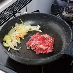フライパンにオリーブ油大さじ１とにんにくを入れてから中火にかけ、香りがたってきたら玉ねぎを加えて約１分炒める。フライパンの中心を空けて牛肉を入れ、崩さないで焼く。
