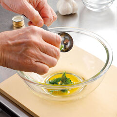 ボウルにオリーブオイルと塩を入れて混ぜ、ちぎったバジルの葉を加えてなじませておく。