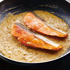 （２）で取り出した銀鮭を、皮を上にしてフライパンに戻し、ソースの中で十分に温めたら器に盛り、ソースをかける。