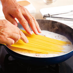 沸騰したら弱火にしてスパゲッティ１.６ｍｍの片側が沈むように入れ、１分程度そのまま置く。スープに浸った側が柔らかくなったら、スパゲッティを曲げるようにして全体を浸してから中火にし、６分間茹でる。