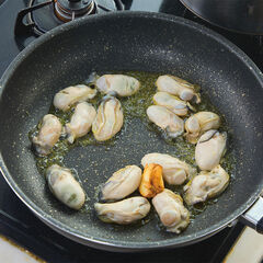 フライパンにオリーブオイル、にんにくを入れ弱火にかける。香りがたったらかきを加え、強火で片面だけ焼く。焼き色が付いたら取り出す。