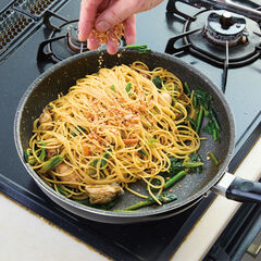 ほうれん草を加えて中火にかけ、やわらかくなったら（１）のかきを戻す。（２）のスパゲッティを加えて全体をからめ、味見をして塩で味を調整し、バターを加えソースが乳化するようからめる。火を止め、柿の種を半量加え混ぜ込む。