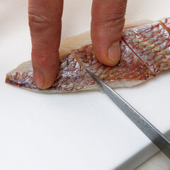 真鯛は皮目に軽く切れ目を入れる。塩をふり１０分おき、表面の水分を拭く。にんにくは潰して、芽と皮を取り除く。